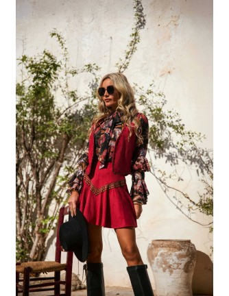 Chaleco Briar Camaleónica by Capriche, ante burdeos con tachuelas doradas, conjunto con blusa Trovan y falda Solvik