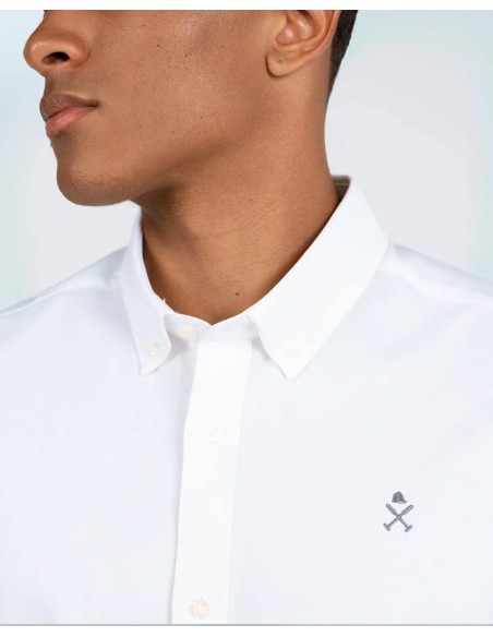 Detalle del cuello button-down y logo bordado de la camisa Oxford blanca