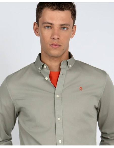 Detalle del cuello button-down y logo naranja de la camisa Garment Dye
