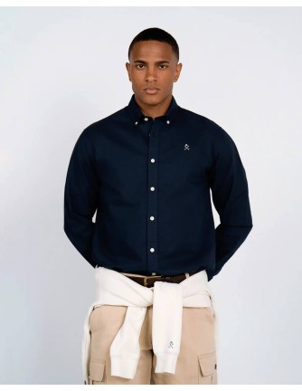 Detalle del cuello button-down y logo bordado de la camisa Oxford azul marino