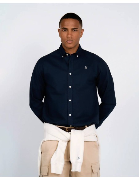 Detalle del cuello button-down y logo bordado de la camisa Oxford azul marino