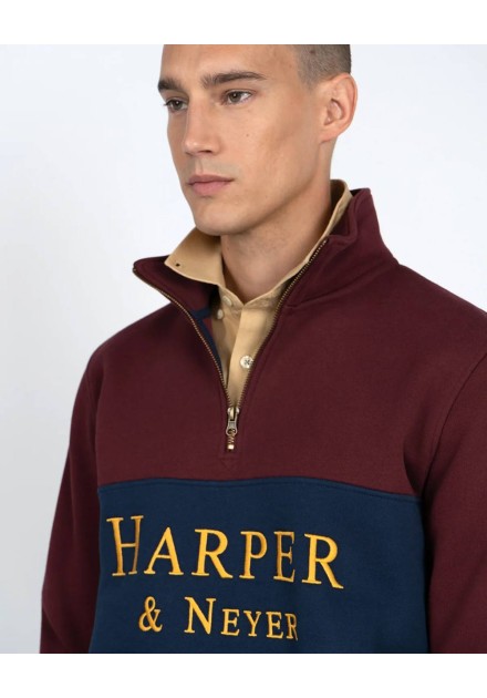 Detalle del logo dorado Harper & Neyer y cuello con cremallera de la sudadera granate