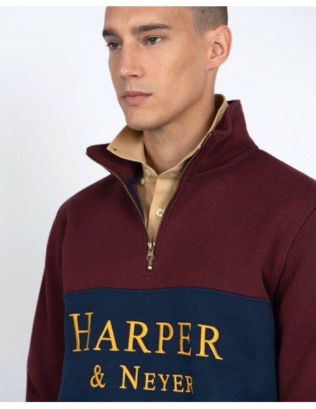 Detalle del logo dorado Harper & Neyer y cuello con cremallera de la sudadera granate