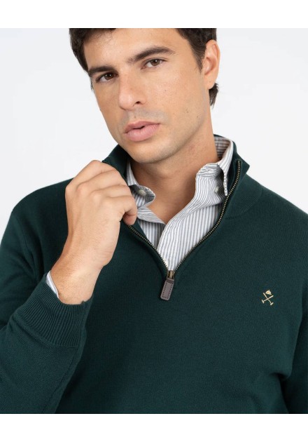 Detalle del cuello con cremallera y logo bordado del jersey verde