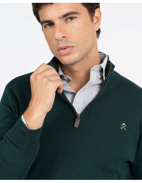 Detalle del cuello con cremallera y logo bordado del jersey verde