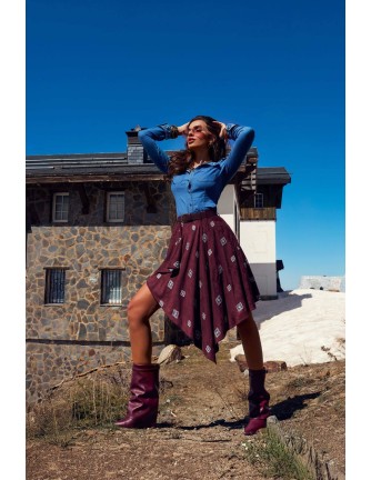 Falda Coldwyn Camaleónica by Capriche burdeos asimétrica con estampado, look con camisa vaquera