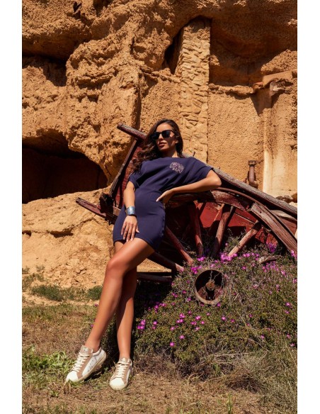 Vestido Aven Camaleónica by Capriche, pose recostada entre piedra y madera