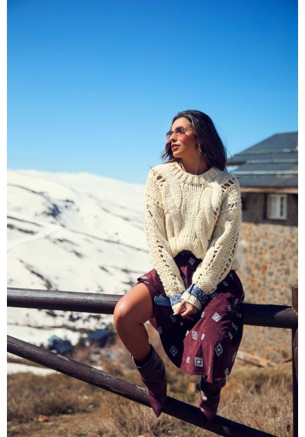 Ropa Camaleónica: jersey Roamer de punto crudo sentada en valla con falda estampada Ropa Camaleónica: jersey Roamer de punto crudo sentada en valla con falda estampada