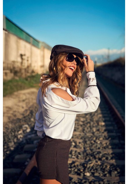 Ropa Camaleónica: camisa Summit blanca con gorra y gafas de sol junto a las vías