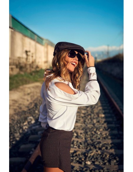 Ropa Camaleónica: camisa Summit blanca con gorra y gafas de sol junto a las vías